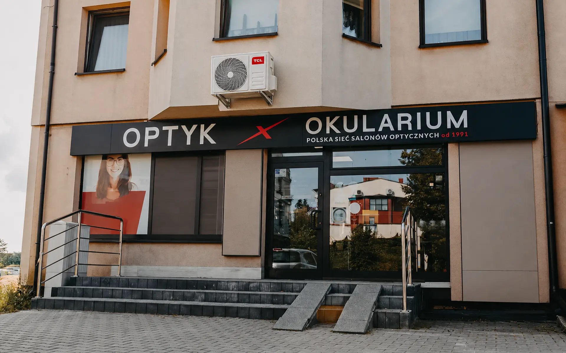 Montaż klimatyzacji w salonie optycznym, budynek z agregatem zewnętrznym